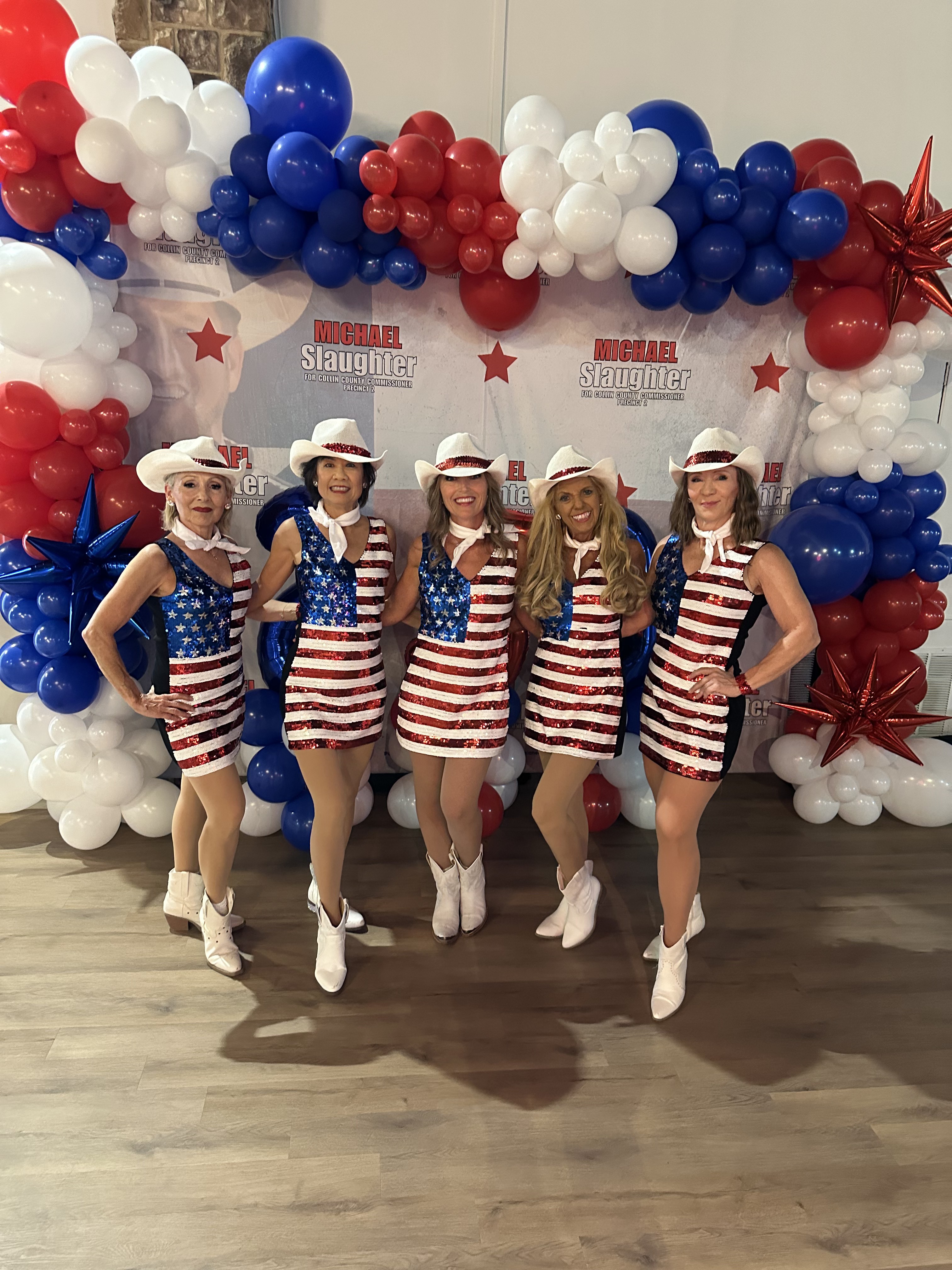 Sassafras Dance Group posing in front of a red, white, and blue balloon arch